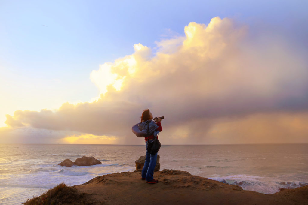 person with camera at the seaside with stormy sky