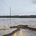 Floodwater covering a rural road.