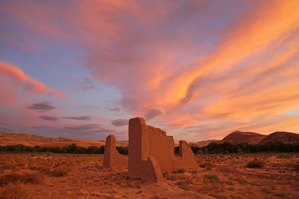 Desert ruins and a colorful sunset sky.