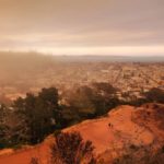 View from above a terraced city park where two people walk and heavy wildfire smoke approaches from the left.